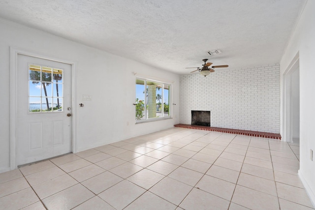 5203 S Indian River Dr, Fort Pierce, FL 34982 - unfurnished living room with plenty of natural light, ceiling fan, a textured ceiling, a fireplace, and light tile patterned flooring