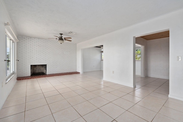 5203 S Indian River Dr, Fort Pierce, FL 34982 - unfurnished living room featuring ceiling fan, light tile patterned floors, a brick fireplace, and a textured ceiling