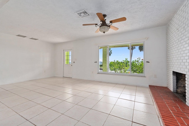 5203 S Indian River Dr, Fort Pierce, FL 34982 - unfurnished living room featuring a brick fireplace, a ceiling fan, a textured ceiling, and light tile patterned floors