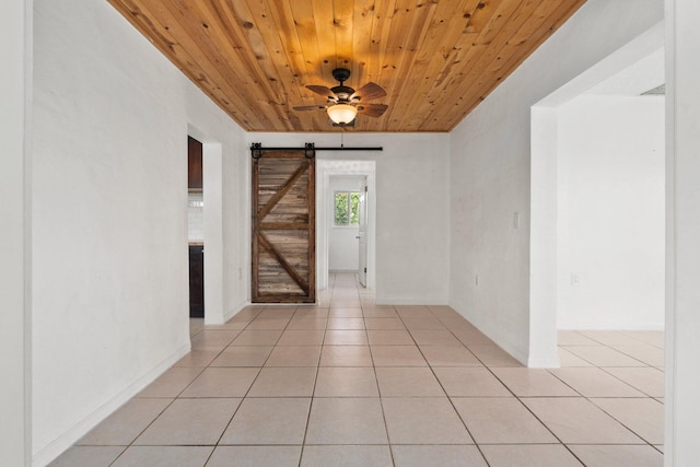 5203 S Indian River Dr, Fort Pierce, FL 34982 - unfurnished room with a barn door, wooden ceiling, light tile patterned floors, and ceiling fan