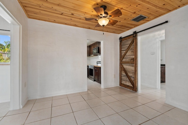 5203 S Indian River Dr, Fort Pierce, FL 34982 - unfurnished room with wooden ceiling, a barn door, light tile patterned floors, and ceiling fan