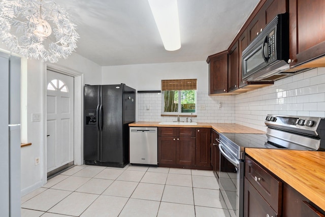 5203 S Indian River Dr, Fort Pierce, FL 34982 - kitchen with black appliances, butcher block counters, tasteful backsplash, and light tile patterned flooring