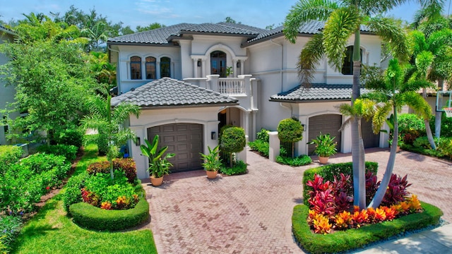 17865 Monte Vista Dr, Boca Raton, FL 33496 - mediterranean / spanish home featuring decorative driveway, a tile roof, a balcony, a garage, and stucco siding