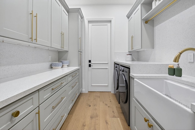 17865 Monte Vista Dr, Boca Raton, FL 33496 - laundry room with washing machine and clothes dryer, cabinet space, and light wood-type flooring
