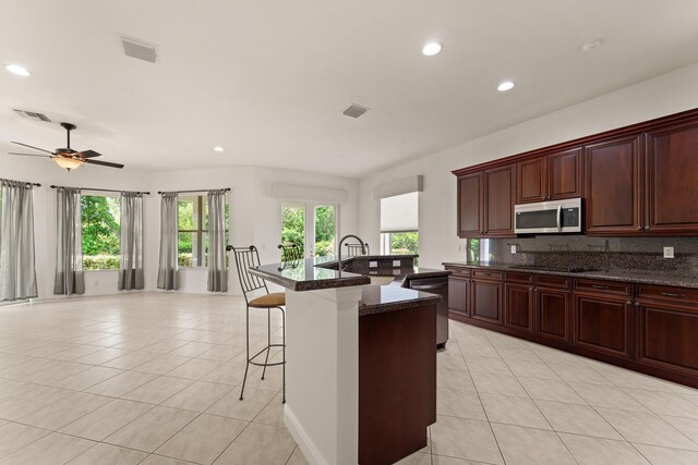 879 SW Pebble Ln, Palm City, FL 34990 - kitchen with appliances with stainless steel finishes, light tile patterned floors, a breakfast bar, plenty of natural light, and recessed lighting
