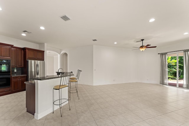 879 SW Pebble Ln, Palm City, FL 34990 - kitchen with freestanding refrigerator, arched walkways, a kitchen bar, recessed lighting, and ceiling fan
