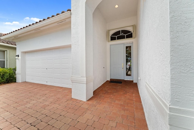 879 SW Pebble Ln, Palm City, FL 34990 - property entrance featuring stucco siding, an attached garage, and a tiled roof
