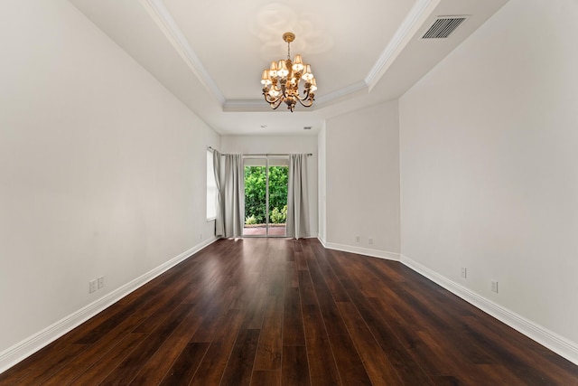 879 SW Pebble Ln, Palm City, FL 34990 - spare room with a chandelier, dark wood-style flooring, a tray ceiling, and ornamental molding
