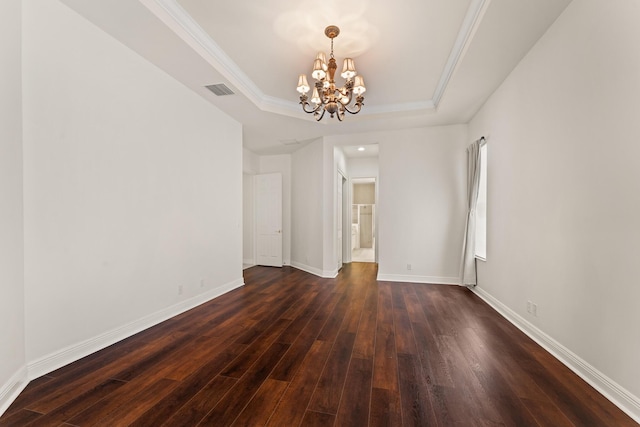 879 SW Pebble Ln, Palm City, FL 34990 - empty room with a tray ceiling, a chandelier, dark wood-style floors, and ornamental molding