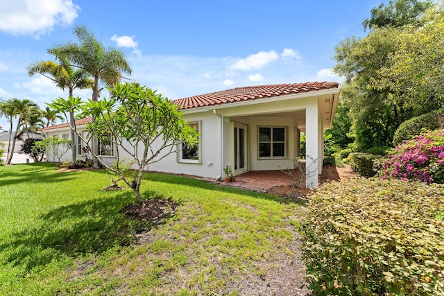 879 SW Pebble Ln, Palm City, FL 34990 - back of property featuring a tiled roof, a yard, and stucco siding