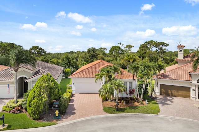 879 SW Pebble Ln, Palm City, FL 34990 - mediterranean / spanish-style home with driveway, stucco siding, an attached garage, and a tiled roof