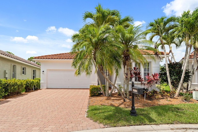 879 SW Pebble Ln, Palm City, FL 34990 - mediterranean / spanish-style home with driveway, an attached garage, a tile roof, and stucco siding