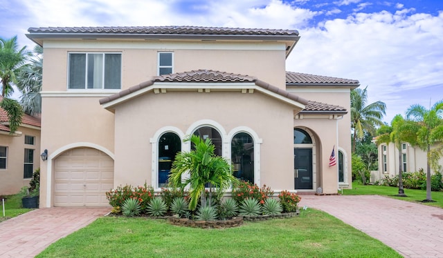 1207 Creek Side Dr, Wellington, FL 33414 - mediterranean / spanish-style home featuring a tiled roof, a front lawn, decorative driveway, stucco siding, and a garage