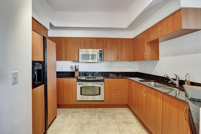 804 E Windward Way Unit 606, Lantana, FL 33462 - kitchen featuring appliances with stainless steel finishes, dark stone countertops, and brown cabinets