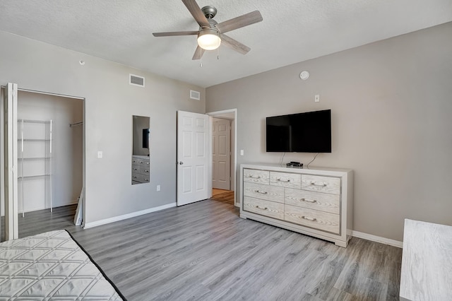804 E Windward Way Unit 606, Lantana, FL 33462 - bedroom featuring wood finished floors, ceiling fan, a textured ceiling, a spacious closet, and a closet