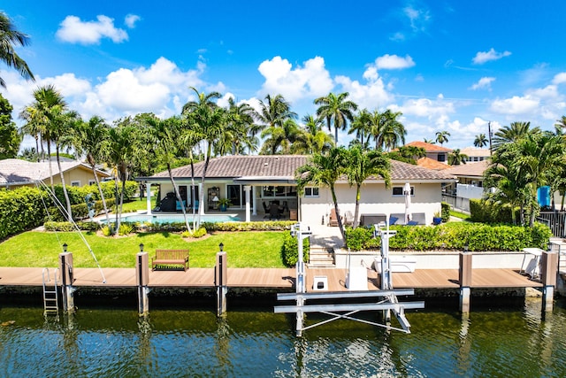 4220 NE 24th Ave, Lighthouse Point, FL 33064 - rear view of house with boat lift, a water view, a swimming pool, and stucco siding