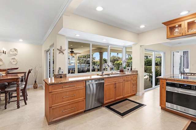 4220 NE 24th Ave, Lighthouse Point, FL 33064 - kitchen featuring appliances with stainless steel finishes, crown molding, brown cabinetry, stone counters, and recessed lighting