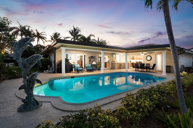 4220 NE 24th Ave, Lighthouse Point, FL 33064 - pool at dusk with french doors, a patio, an outdoor pool, and a grill