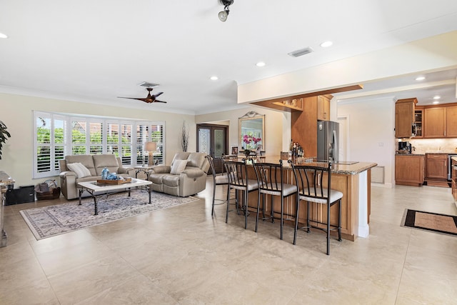 4220 NE 24th Ave, Lighthouse Point, FL 33064 - kitchen featuring stainless steel fridge, ornamental molding, a breakfast bar, brown cabinets, and open floor plan