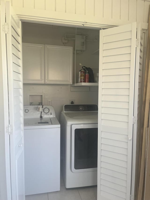 2548 Ida Way Unit 3A, West Palm Beach, FL 33415 - washroom with cabinet space, separate washer and dryer, and light tile patterned floors