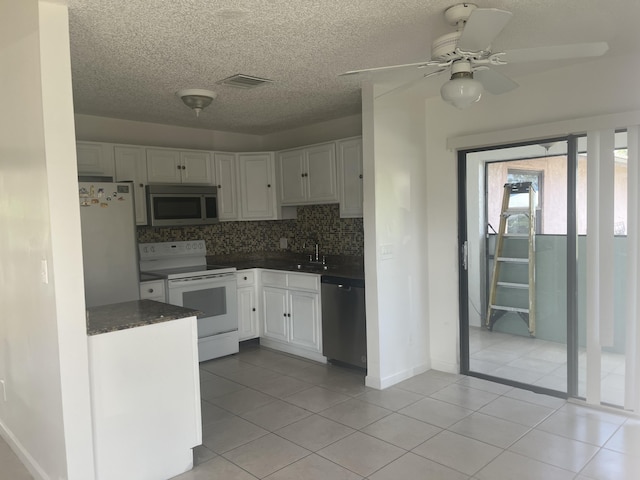 2548 Ida Way Unit 3A, West Palm Beach, FL 33415 - kitchen featuring appliances with stainless steel finishes, dark countertops, a ceiling fan, white cabinetry, and a textured ceiling