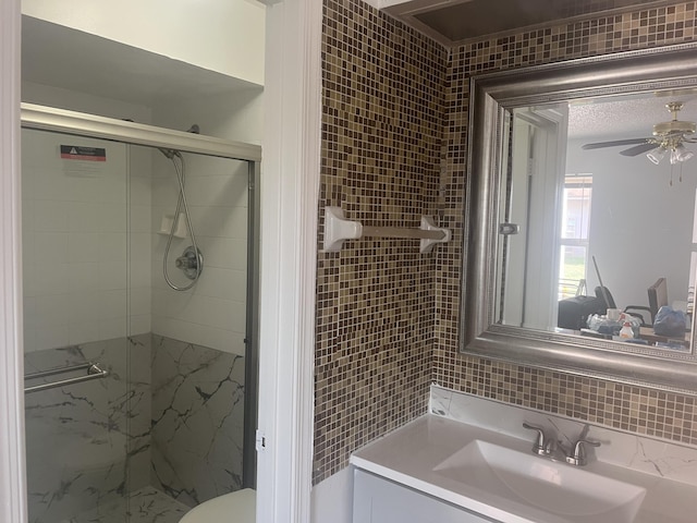 2548 Ida Way Unit 3A, West Palm Beach, FL 33415 - bathroom with a stall shower, ceiling fan, vanity, tile walls, and tasteful backsplash