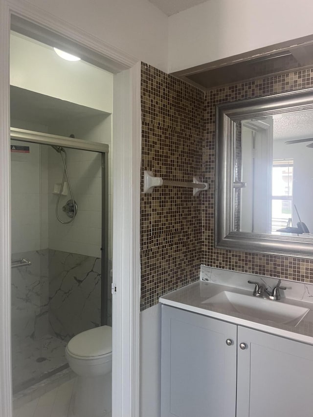 2548 Ida Way Unit 3A, West Palm Beach, FL 33415 - bathroom featuring a shower stall, vanity, tile walls, and backsplash