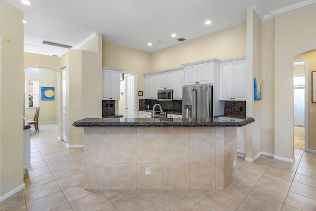 5422 Landon Cir, Boynton Beach, FL 33437 - kitchen with stainless steel appliances, arched walkways, light tile patterned flooring, tasteful backsplash, and dark stone counters