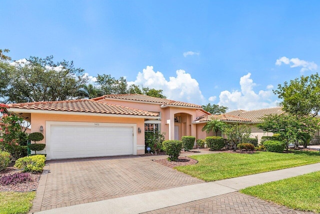 5422 Landon Cir, Boynton Beach, FL 33437 - mediterranean / spanish-style home with decorative driveway, stucco siding, an attached garage, a front yard, and a tile roof