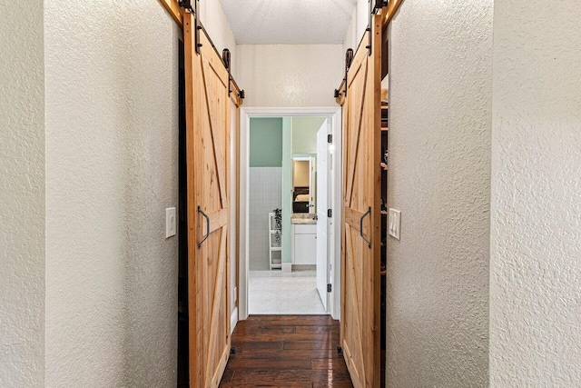 5336 NW 57th Way, Coral Springs, FL 33067 - hall with a barn door, a textured wall, and dark wood-style flooring