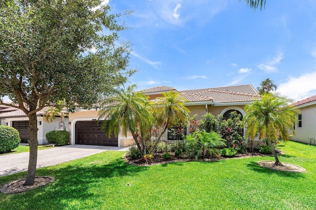 5336 NW 57th Way, Coral Springs, FL 33067 - mediterranean / spanish-style house featuring a garage, driveway, a tile roof, a front yard, and stucco siding
