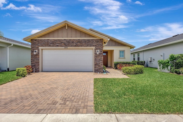 556 SE Mulberry Way, Port Saint Lucie, FL 34984 - ranch-style home with stone siding, decorative driveway, a front lawn, and an attached garage