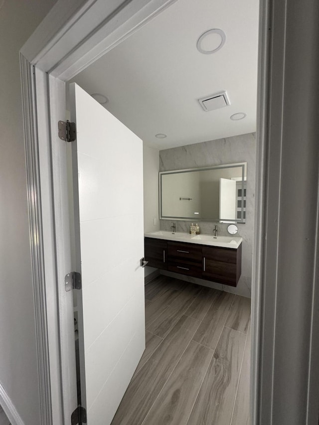 8711 Eagle Run Dr, Boca Raton, FL 33434 - bathroom featuring double vanity and wood finished floors