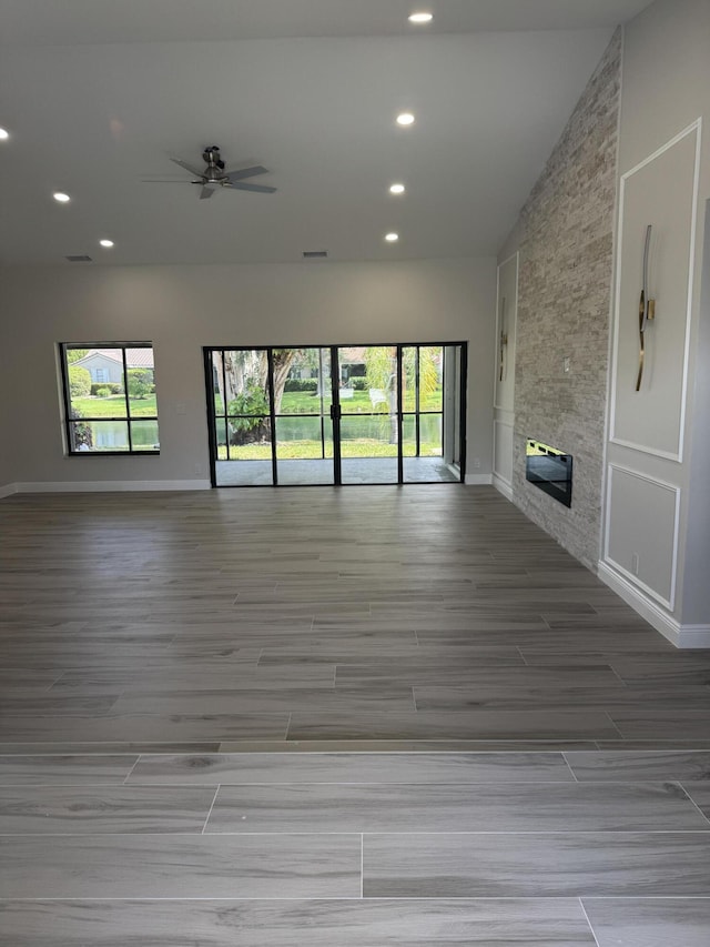 8711 Eagle Run Dr, Boca Raton, FL 33434 - unfurnished living room with wood finished floors, plenty of natural light, recessed lighting, ceiling fan, and a large fireplace