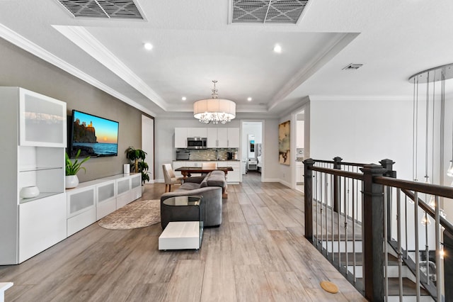 4112 Italia Way, Lake Worth, FL 33467 - living area featuring a tray ceiling, a chandelier, recessed lighting, ornamental molding, and light wood finished floors