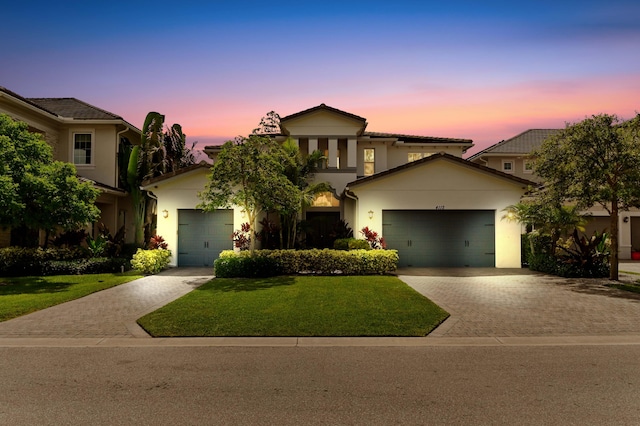 4112 Italia Way, Lake Worth, FL 33467 - mediterranean / spanish-style home featuring decorative driveway, stucco siding, a garage, and a front lawn