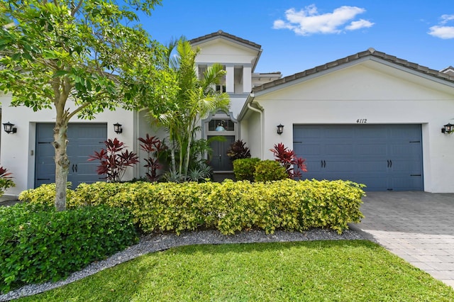 4112 Italia Way, Lake Worth, FL 33467 - view of front facade with stucco siding, a garage, decorative driveway, and a front lawn