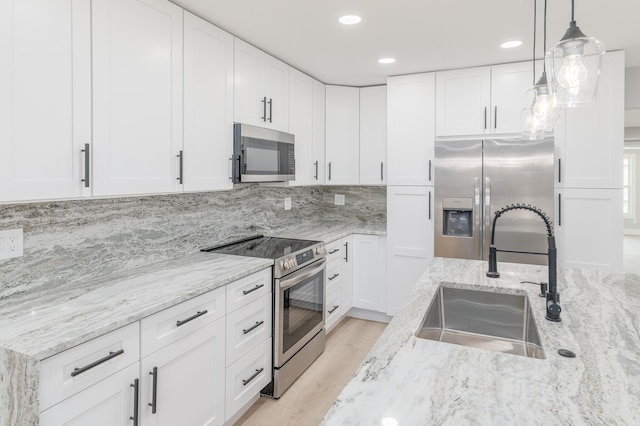 2058 SE Watercrest St, Port Saint Lucie, FL 34984 - kitchen with stainless steel appliances, light wood-style flooring, white cabinets, and recessed lighting