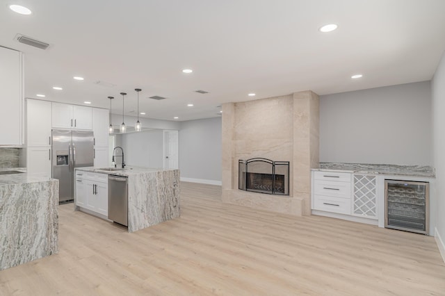 2058 SE Watercrest St, Port Saint Lucie, FL 34984 - kitchen with beverage cooler, stainless steel appliances, light wood-style floors, light stone counters, and recessed lighting