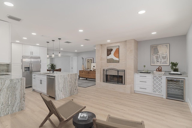 2058 SE Watercrest St, Port Saint Lucie, FL 34984 - living area with beverage cooler, light wood finished floors, a fireplace, recessed lighting, and wet bar