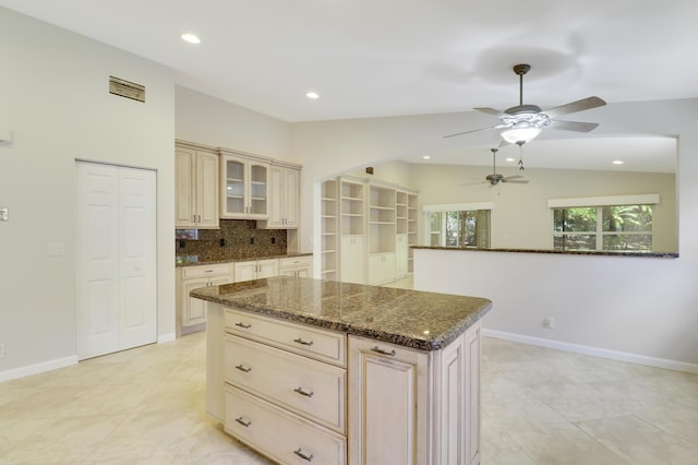1466 Artimino Ln, Boynton Beach, FL 33436 - kitchen featuring vaulted ceiling, ceiling fan, cream cabinets, dark stone counters, and glass insert cabinets