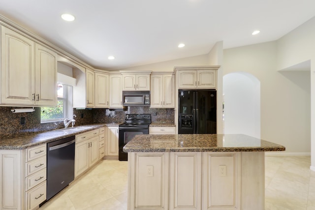 1466 Artimino Ln, Boynton Beach, FL 33436 - kitchen with black appliances, arched walkways, cream cabinetry, a kitchen island, and tasteful backsplash