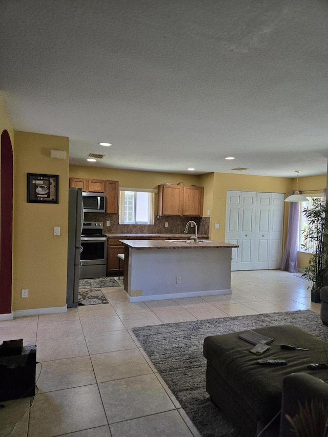 2137 Little Torch St, Riviera Beach, FL 33407 - kitchen with stainless steel appliances, tasteful backsplash, plenty of natural light, brown cabinets, and recessed lighting