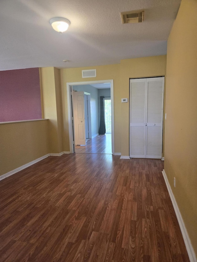 2137 Little Torch St, Riviera Beach, FL 33407 - unfurnished bedroom with dark wood-style floors, a closet, and a textured ceiling