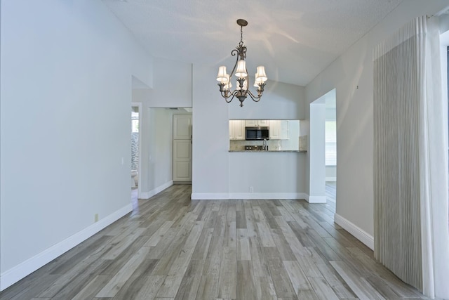 166 Bayberry Cir, Jupiter, FL 33458 - unfurnished living room featuring a chandelier, light wood-style flooring, and lofted ceiling