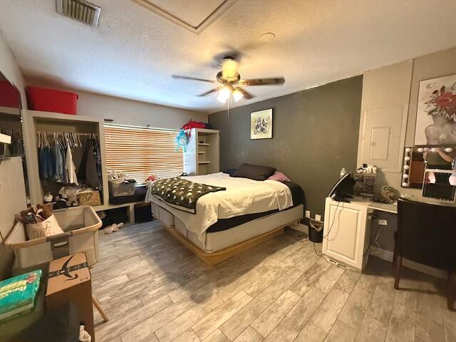 15252 74th St Unit N, The Acreage, FL 33470 - bedroom featuring light wood-style floors, a textured ceiling, and ceiling fan