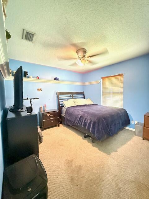 15252 74th St Unit N, The Acreage, FL 33470 - carpeted bedroom featuring a textured ceiling and a ceiling fan