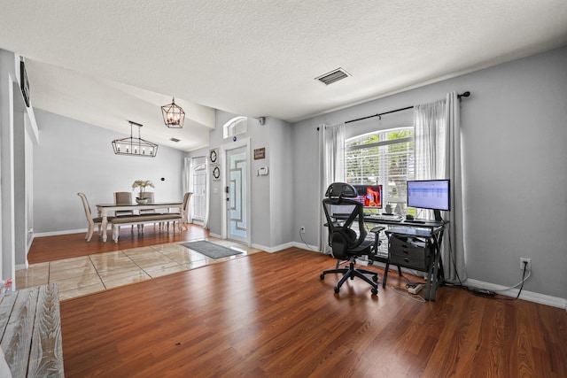 421 NW Cornell Ave, Port Saint Lucie, FL 34983 - home office featuring wood finished floors, a chandelier, and a textured ceiling