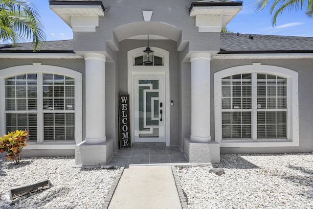 421 NW Cornell Ave, Port Saint Lucie, FL 34983 - doorway to property with a shingled roof and stucco siding