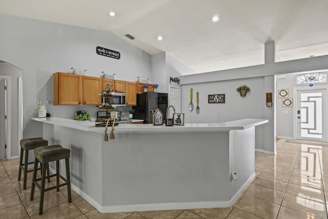 421 NW Cornell Ave, Port Saint Lucie, FL 34983 - kitchen featuring stainless steel appliances, light countertops, high vaulted ceiling, a breakfast bar, and arched walkways